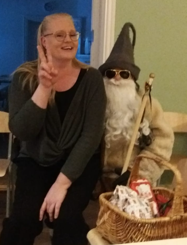 Joulupukin sylissä istuu hymyilevä nainen